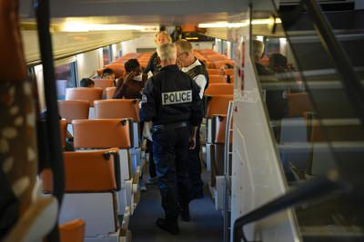 Policías franceses detienen a una mujer que viaja sin documentos en un tren que cruza de Italia a Francia, en la estación de trenes Menton Garavan en Menton, Francia, el domingo 13 de noviembre de 2022. (AP Foto/Daniel Cole)