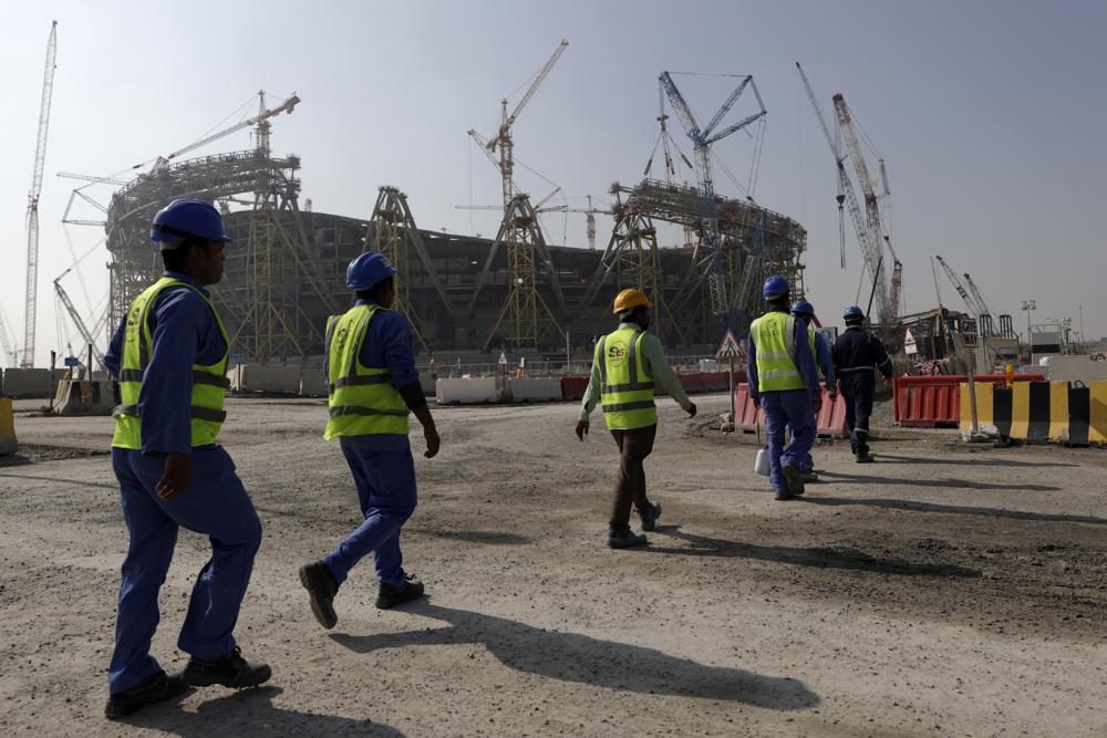 ARCHIVO - Obreras caminan hacia el estadio Lusail, uno de los escenarios de la Copa Mundial de 2022 en Qatar, el 20 de diciembre de 2019. (AP Foto/Hassan Ammar)