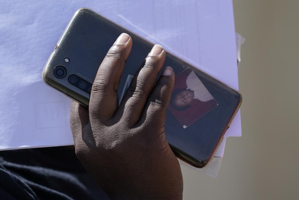 Un migrante sostiene su celular, con una fotografía en la funda, a su llegada a un centro de ayuda humanitaria tras ser liberado por la Patrulla Fronteriza de Estados Unidos tras cruzar el Río Bravo y entregarse a las autoridades para solicitar asilo, el 22 de septiembre de 2021, en Del Rio, Texas. (AP Foto/Julio Cortez)