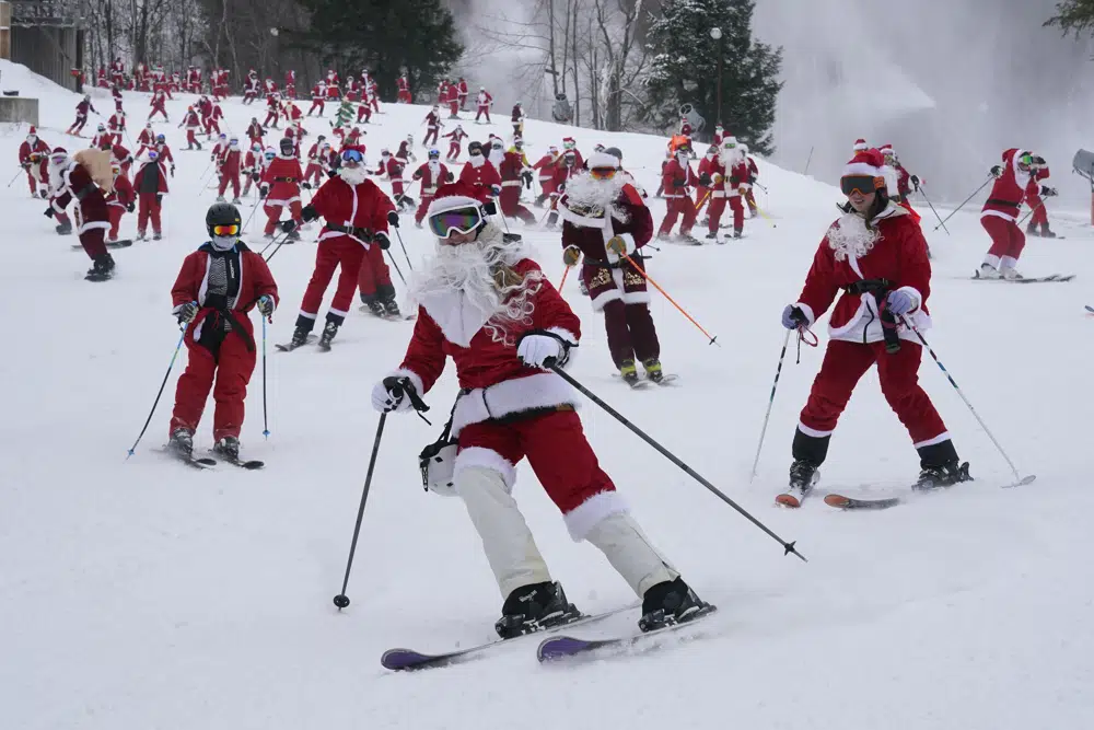 Skiers dressed in Santa Claus outfits hit the slopes for charity at the Sunday River Ski Resort, Sunday, Dec. 11, 2022, in Newry, Maine. (AP Photo/Robert F. Bukaty)