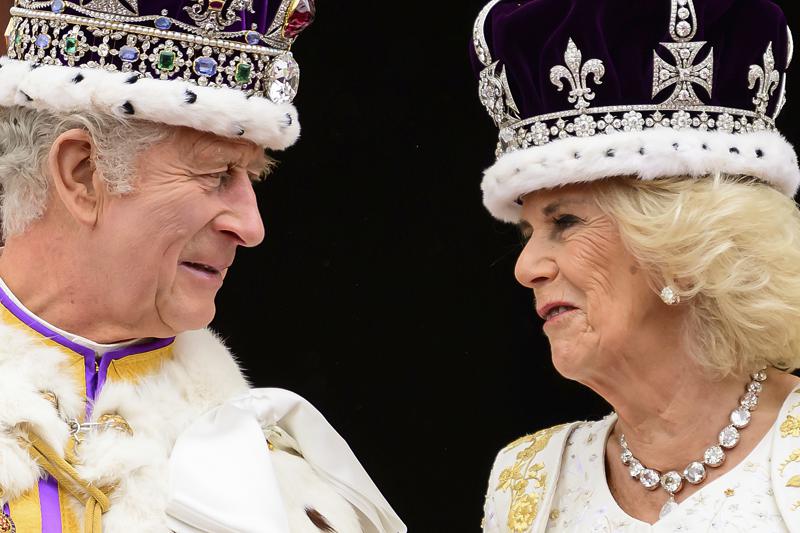 El rey Carlos III y la reina Camilla de Gran Bretaña se miran mientras se paran en el balcón del Palacio de Buckingham después de su coronación, en Londres, el sábado 6 de mayo de 2023. (Leon Neal/Pool Photo vía AP)