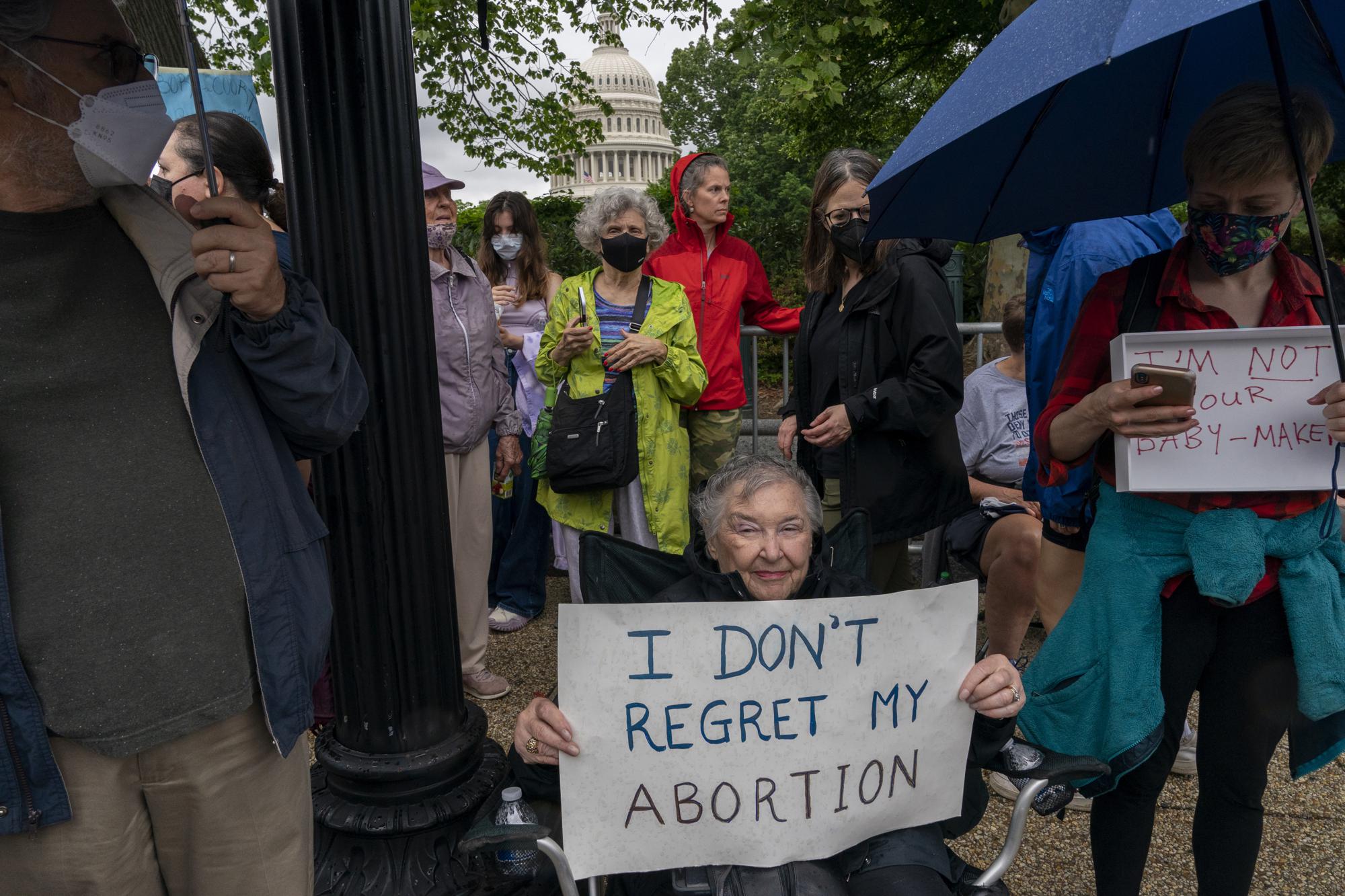 Benita Lubic, 85, of Washington, holds a sign saying, "I don't regret my abortion," as she poses for a portrait while joining abortion rights demonstrators, Saturday, May 14, 2022, by the U.S. Capitol across from the Supreme Court in Washington. "I had an abortion in 1968," says Lubic, "three children was enough and I'm not unhappy about my decision. But I had to see a psychiatrist to get his approval, it was a sham." Lubic and her daughter came out to protest. "I want to protect children who are raped from being denied an abortion," says Lubic, "I'm just sorry that Ruth Bader Ginsburg isn't alive to support us." (AP Photo/Jacquelyn Martin)