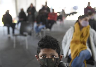 Jóvenes esperan una dosis de la vacuna Moderna para el COVID-19, donada por el gobierno de Estados Unidos, en un centro de salud en Quilmes, Argentina, el martes 3 de agosto de 2021. Argentina está vacunando a jóvenes con afecciones preexistentes entre 12 y 17 años. (AP Foto/Gustavo Garello)