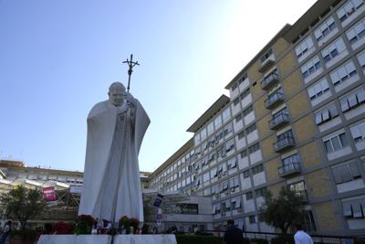 Una estatua del papa Juan Pablo II ante la entrada de la Policlínica Agostino Gemelli en Roma, el miércoles 7 de julio de 2021, donde estaba ingresado el papa Francisco. (AP Foto/Alessandra Tarantino)