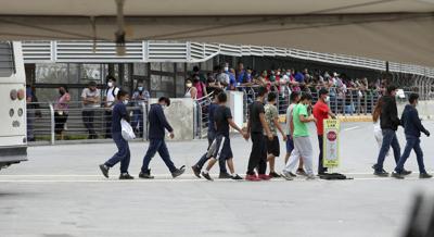 Varios inmigrantes son escoltados hacia un autobús en el Puente Internacional Hidalgo, el miércoles 2 de junio de 2021, en Hidalgo, Texas. (Delcia Lopez/The Monitor vía AP)