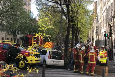 Bomberos reunidos cerca de una calle donde se derrumbó un edificio la madrugada del domingo 9 de abril de 2023 en Marsella, en el sur de Francia. (AP Foto/Bishr El Touni)