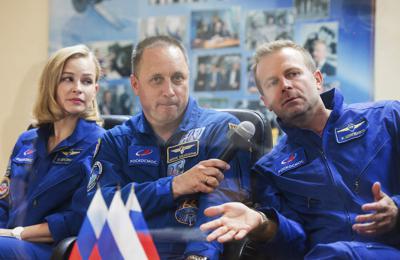 En esta foto proporcionada por Roscosmos, la actriz Yulia Peresild, el director Klim Shipenko y el cosmonauta Anton Shkaplerov, de izquierda a derecha, miembros de la tripulación principal de la nave espacial Soyuz MS-19, dan una conferencia de prensa en las instalaciones de lanzamiento rusas en el cosmódromo de Baikonur, Kazajstán, el lunes 4 de octubre de 2021. (Roscosmos Space Agency vía AP)