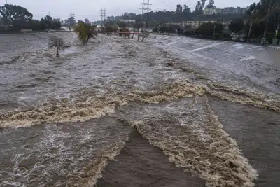 FILE - The Los Angeles River flows downstream in Los Angeles, Jan. 14, 2023. In Los Angeles, a complex system of dams and paved flood control channels including the river were designed to steer water away from roads and buildings and out to sea as fast as possible. But with water sources becoming scarce, efforts are underway to begin capturing and treating some of the runoff for irrigation or to inject in aquifers. (AP Photo/Damian Dovarganes, File)