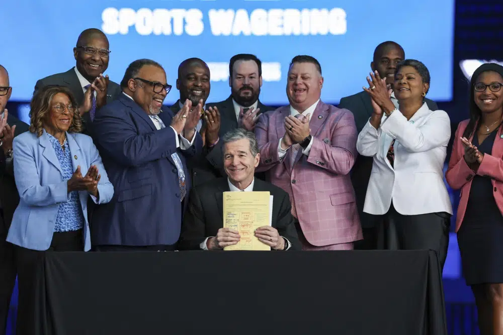 Gov. Roy Cooper signs House Bill 347: Sports Wagering/Horse Racing Wagering into law on Wednesday, June 14, 2023 at Spectrum Center in Charlotte, N.C. Regulated sports betting and horse racing should begin across North Carolina in the first half of next year after Gov. Roy Cooper signed into law Wednesday legislation that greatly expands gambling opportunities in the ninth-largest state.(Melissa Melvin-Rodriguez/The Charlotte Observer via AP)