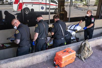 Equipos de auxilio responden a un reporte de que alguien sufrió deshidratación por calor en Salem, Oregon, el 26 de junio del 2021.  (Foto AP/Nathan Howard)