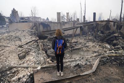 Cathy Glaab revisa lo que quedó de su casa luego de que un incendio forestal arrasó con su vecindario en Superior, Colorado, el viernes 31 de diciembre de 2021. (AP Foto/Brittany Peterson)