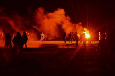 Jóvenes en un campo durante enfrentamientos con la policía mientras los agentes buscaban disolver una fiesta rave no autorizada cerca de Redon, Francia, la noche del viernes 18 de junio de 2021. (AP Foto)