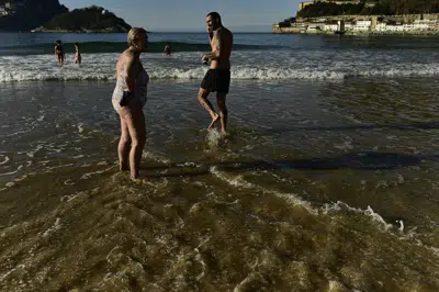 La gente visita la playa de La Concha en San Sebastián, norte de España, el miércoles 4 de enero de 2023. (Foto AP/Álvaro Barrientos)