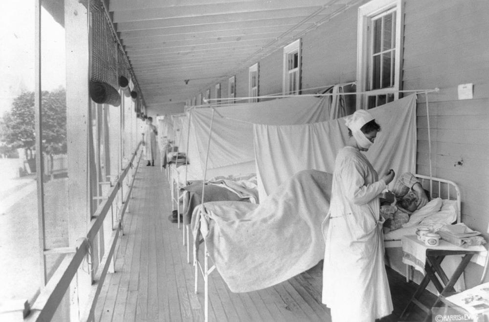 FILE - In this November 1918 photo made available by the Library of Congress, a nurse takes the pulse of a patient in the influenza ward of the Walter Reed hospital in Washington. Historians think the pandemic started in Kansas in early 1918, and by winter 1919 the virus had infected a third of the global population and killed at least 50 million people, including 675,000 Americans. Some estimates put the toll as high as 100 million. (Harris & Ewing/Library of Congress via AP, File)