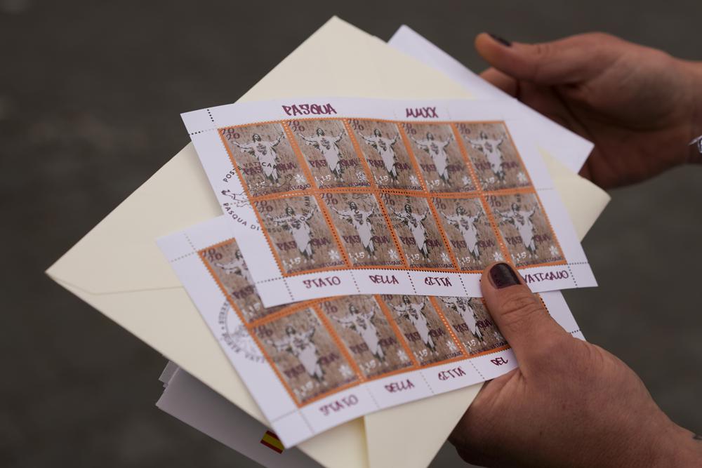 La artista Alessia Babrow muestra los sellos del Vaticano durante una entrevista con Associated Press, en el Vaticano, el viernes 14 de mayo de 2021. Babrow demandó a la oficina de telecomunicaciones del Estado de la Ciudad del Vaticano en un tribunal de Roma el mes pasado, diciendo que se estaba aprovechando injustamente de su creatividad y violando la intención original de su obra de arte. La demanda, que busca casi 130.000 euros en daños y perjuicios, dijo que el Vaticano había ignorado los intentos de Babrow de negociar un acuerdo después de que descubrió que había reproducido ilegalmente el arte de su cartel. (Foto AP / Andrew Medichini)