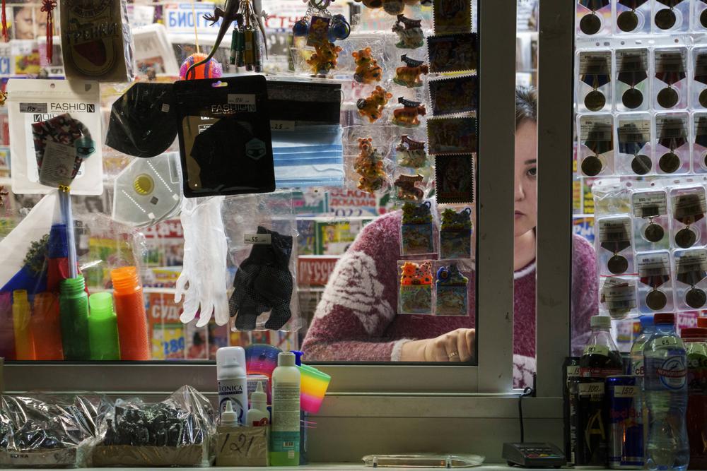 Una vendedora espera a sus clientes en un kiosco donde se venden mascarillas y guantes, entre otros artículos, en Moscú, Rusia, el 18 de noviembre de 2021. (AP Foto)