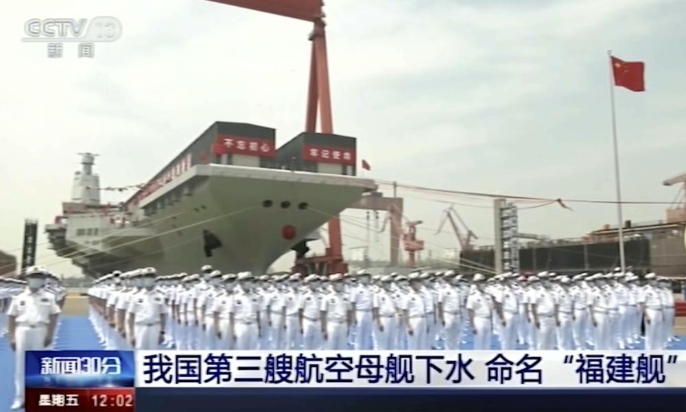 In this image taken from video footage run by China's CCTV, sailors line up in front of China's third aircraft carrier christened Fujian before its launching ceremony at a dry dock in Shanghai on Friday, June 17, 2022. State media reported that China on Friday launched its third aircraft carrier, the first such ship to be both designed and built entirely within the country. Chinese characters on screen reads "Our country's third aircraft carrier launched into water, named Fujian" (CCTV via AP)