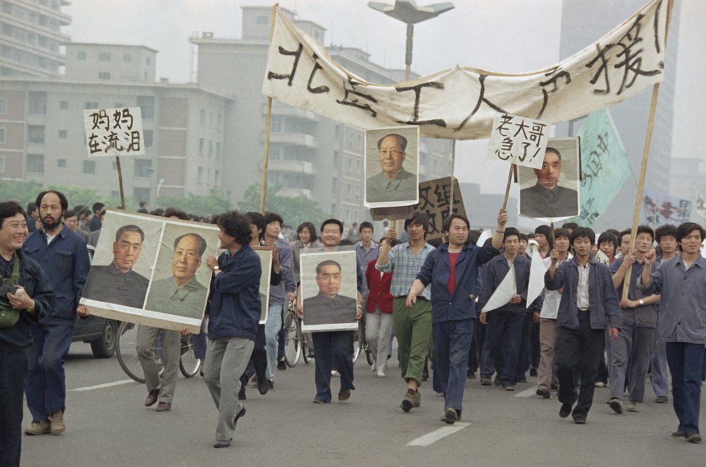 FILE - In this May 18, 1989 file photo, pro Democracy demonstrators carry portraits of former Chinese rulers Mao Tse-Tung and Chou En-Lai as they march to join student strikers at Tiananmen Square, Beijing, China. Over seven weeks in 1989, the student-led pro-democracy protests centered on Beijing’s Tiananmen Square became China’s greatest political upheaval since the end of the decade-long Cultural Revolution more than a decade earlier. (AP Photo/Sadayuki Mikami, File)