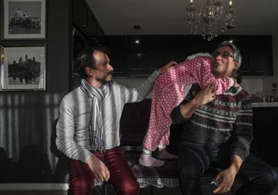 Yanay, de 7 años, abraza a su padre Rodrigo González, junto a su padre legalmente reconocido Cristian Escalona, ​​quien tuvo que deshacer su unión civil con González para poder adoptar a sus hijos como padre soltero, en su casa de Santiago, Chile, el miércoles 21 de julio de 2021. (AP Foto/Esteban Felix)