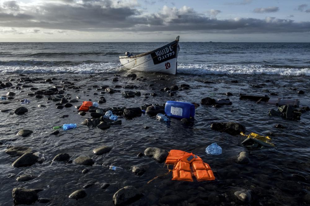 FILE - In this Oct. 16, 2020 file photo, a wooden boat used by migrants from Morocco sits on the shore on the coast of the Canary Island of Gran Canaria, Spain. Migrant deaths along the Atlantic route from West Africa to Spain's Canary Islands reached a record high last month with 379 lives lost, the International Organization for Migration said Friday Sept. 24, 2021. Those deaths account for nearly half the total number of casualties for all of 2021, 735 adults and 50 children, according to the United Nations agency's Missing Migrants Project. (AP Photo/Javier Bauluz, File)