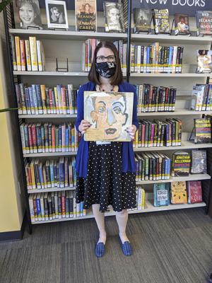 En esta fotografía proporcionada por Heights Libraries, Sara Phillips, gerente de la sucursal de la red de bibliotecas en Ohio, sostiene el álbum doble de Bob Dylan "Self Portrait" que Howard Simon alquiló en 1973, cuando era un estudiante de octavo grado, y devolvió recientemente, 48 años después de la fecha de retorno. (Heights Libraries vía AP)