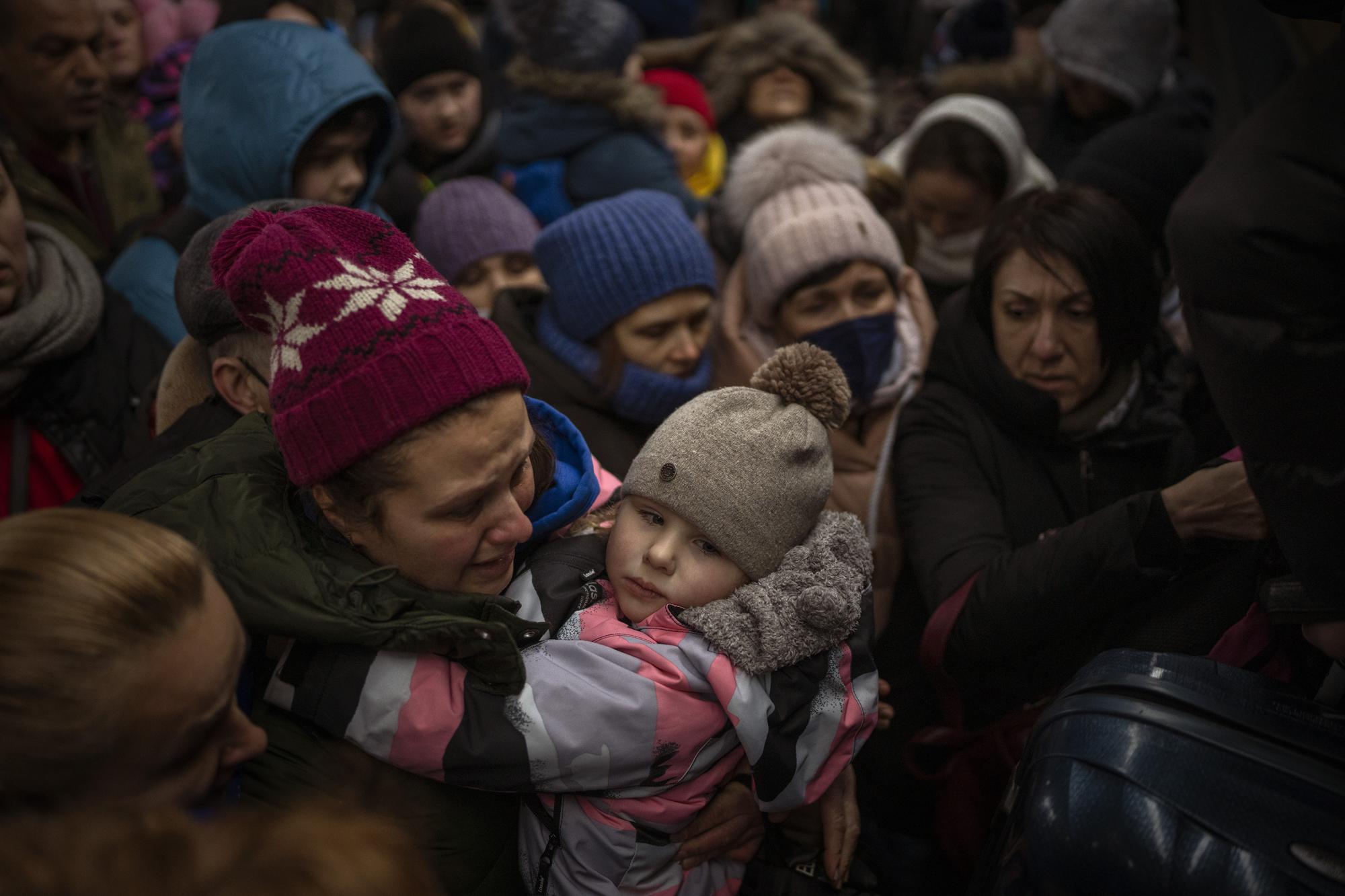 Women and children try to get onto a train bound for Lviv, at the Kyiv station in Ukraine, Thursday, March 3. 2022. (AP Photo/Emilio Morenatti)