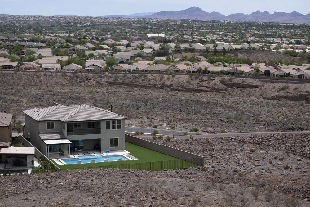 A home with a swimming pool abuts the desert on the edge of the Las Vegas valley, Wednesday, July 20, 2022, in Henderson, Nev. Las Vegas area water officials want to cap the size of new swimming pools, citing worries about supplies from the drying-up Lake Mead reservoir on the depleted Colorado River. (AP Photo/John Locher)