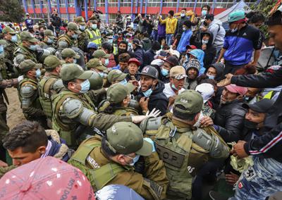 La policía chilena desaloja a migrantes venezolanos y colombianos de la Plaza Brasil donde viven en tiendas de campaña en Iquique, Chile, el viernes 24 de septiembre de 2021.  (AP Foto/Ignacio Muñoz)