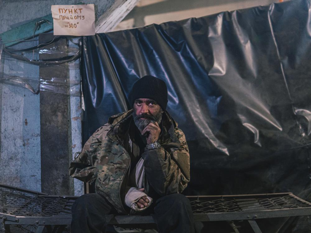 In this photo provided by Azov Special Forces Regiment of the Ukrainian National Guard Press Office, an Azov Special Forces Regiment's serviceman, injured during fighting against Russian forces, poses for a photographer inside the Azovstal steel plant in Mariupol, Ukraine, Tuesday, May 10, 2022. (Dmytro 'Orest' Kozatskyi/Azov Special Forces Regiment of the Ukrainian National Guard Press Office via AP)