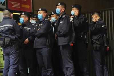 Agentes de policía resguardan el exterior del edificio de oficinas de Stand News, el miércoles 29 de diciembre de 2021, en Hong Kong. (AP Foto/Vincent Yu)