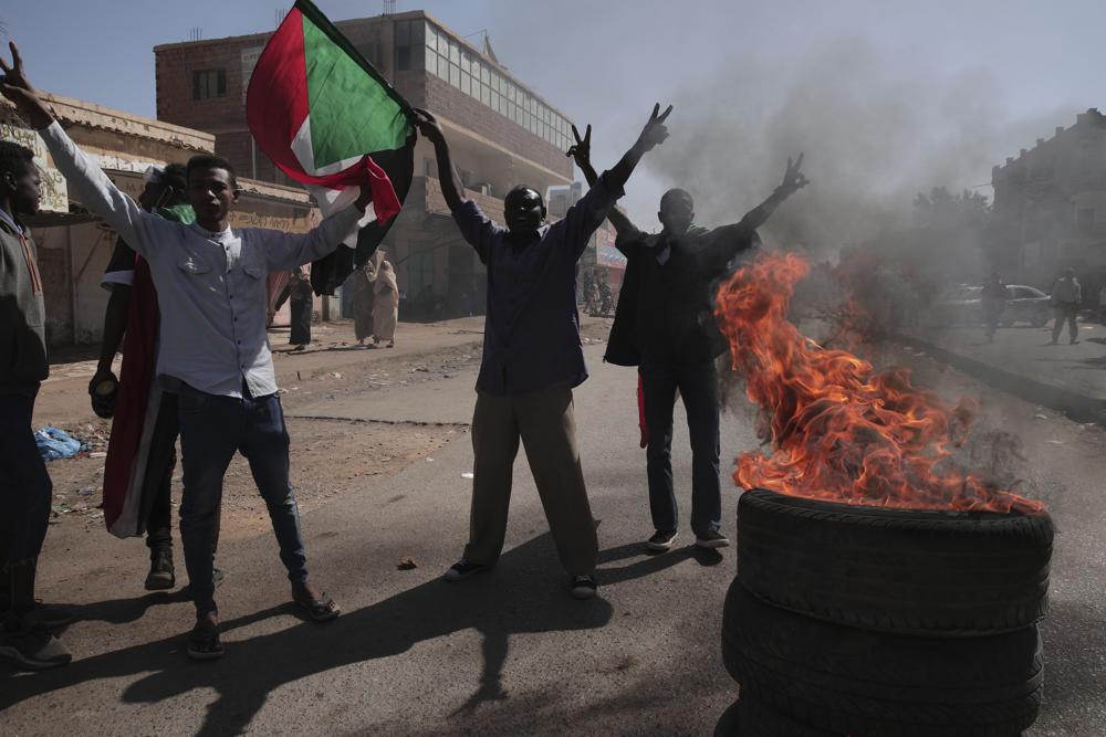 People chant slogans during a protest to denounce the October military coup, in Khartoum, Sudan, Thursday, Dec. 30, 2021.  The October military takeover upended a fragile planned transition to democratic rule and led to relentless street demonstrations across Sudan.   (AP Photo/Marwan Ali)