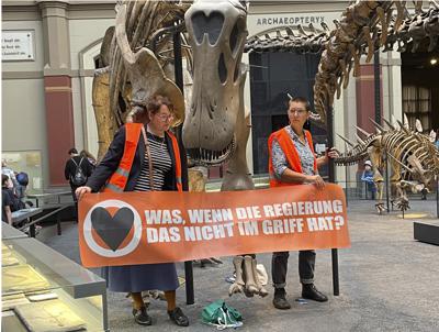 Las activistas que se pegaron a un esqueleto de dinosaurio en el Museo de Historia Natural de Berlín, el 30 de octubre de 2022. (Paul Zinken/dpa via AP)