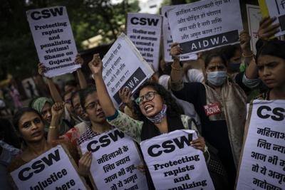 Activistas corean lemas contra la reducción de sentencia autorizada por el gobierno a los autores condenados de una violación grupal, en Nueva Delhi, India, el jueves 18 de agosto de 2022. (AP Foto/Altaf Qadri)