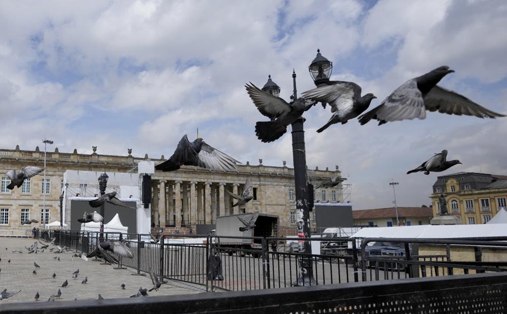 Las palomas vuelan en la plaza de Bolívar, donde se prepara un escenario para la próxima ceremonia de toma de posesión presidencial en Bogotá, Colombia, el jueves 4 de agosto de 2022. El presidente electo Gustavo Petro prestará juramento el 7 de agosto. (AP Foto/Fernando Vergara)