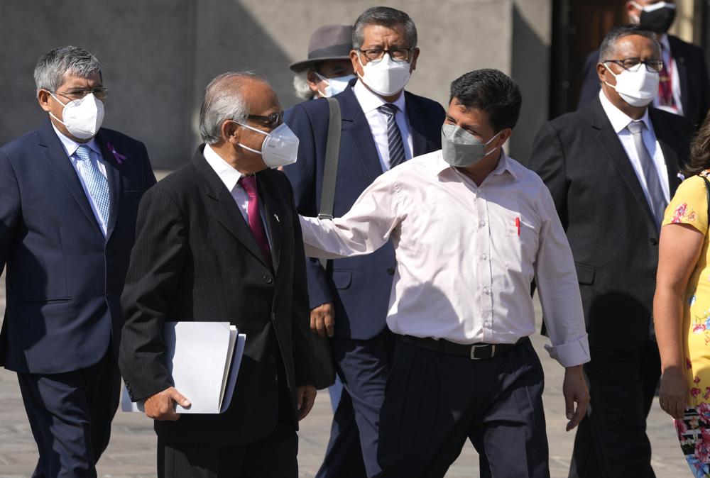 FILE - Peru's President Pedro Castillo, front right, walks alongside Prime Minister Anibal Torres and members of his cabinet outside the government palace in Lima, Peru, March 8, 2022. On Aug. 3, 2022 Torres announced that he presented his resignation to the president, citing personal reasons. (AP Photo/Martin Mejia, File)