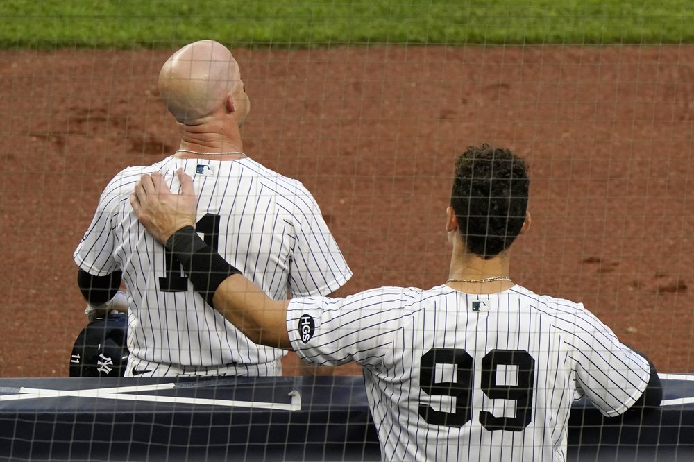 Los Yankees de Nueva York Aaron Judge (99) pone su brazo sobre la espalda de Brett Gardner mientras Gardner toma un descanso durante un cambio de pitcheo en la novena entrada de un juego de la MLB ante los Miami Marlins, el domingo 27 de septiembre de 2020.