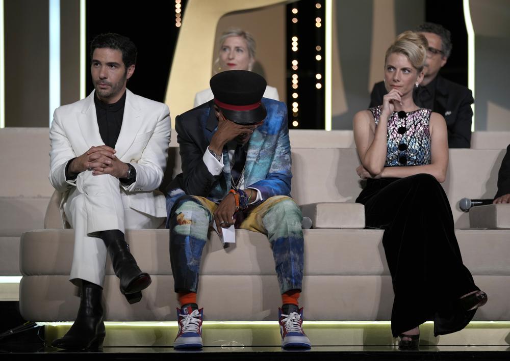 Jury president Spike Lee, center, holds his head in hands after accidentally revealing the film 'Titane' as the winner of the Palme d'Or as jury members Tahar Rahim, left, Jessica Hausner, back center, and Melanie Laurent look on during the awards ceremony at the 74th international film festival, Cannes, southern France, Saturday, July 17, 2021. (AP Photo/Vadim Ghirda)