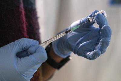 Un enfermero de la Organización Nacional de Salud griega prepara una dosis de la vacuna de Johnson and Johnson contra el COVID-19 en el campo de refugiados Karatepe, isla de Lesbos, Grecia, miércoles 15 de diciembre de 2021. (AP Foto / Panagiotis Balaskas )