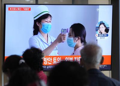 Gente mirando una pantalla de televisión que muestra un reporte noticioso sobre el brote de COVID-19 en Corea del Norte, en una estación de tren de Seúl, Corea del Sur, el sábado 14 de mayo de 2022. . (AP Foto/Ahn Young-joon)
