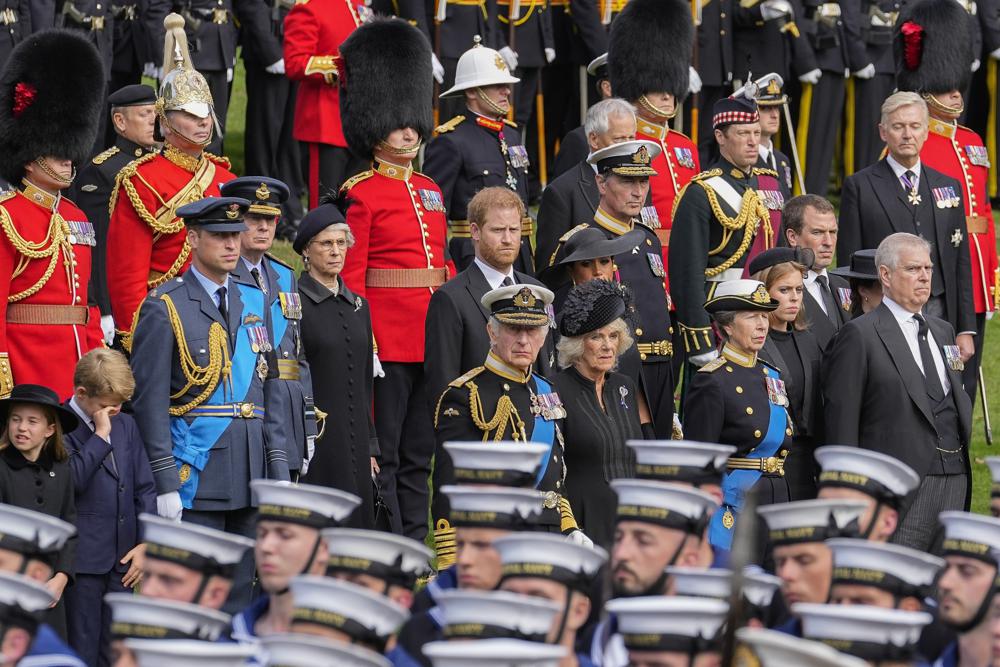 Prince Andrew, from right, Princess Beatrice, Princess Anne, Camilla, the Queen Consort, Britain's King Charles III, Meghan, Duchess of Sussex, Prince Harry, Prince William, Prince George and Princess Charlotte watch as the coffin of Queen Elizabeth II is placed into the hearse following the state funeral service in Westminster Abbey in central London Monday, Sept. 19, 2022. (AP Photo/Martin Meissner, Pool)