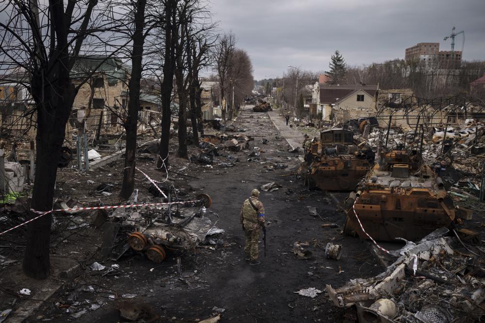 FILE - A Ukrainian serviceman walks amid destroyed Russian tanks in Bucha, on the outskirts of Kyiv, Ukraine, April 6, 2022. Russia is bracing up for a massive new offensive in eastern Ukraine, hoping to reverse its fortunes on the battlefield after a catastrophic start of the invasion. (AP Photo/Felipe Dana, File)