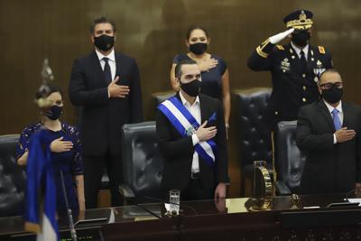 ARCHIVO - El presidente salvadoreño Nayib Bukele, al centro, escucha el himno nacional antes de pronunciar su discurso anual ante el Congreso el 1 de junio de 2021, en San Salvador.  (AP Foto / Salvador Meléndez, archivo)