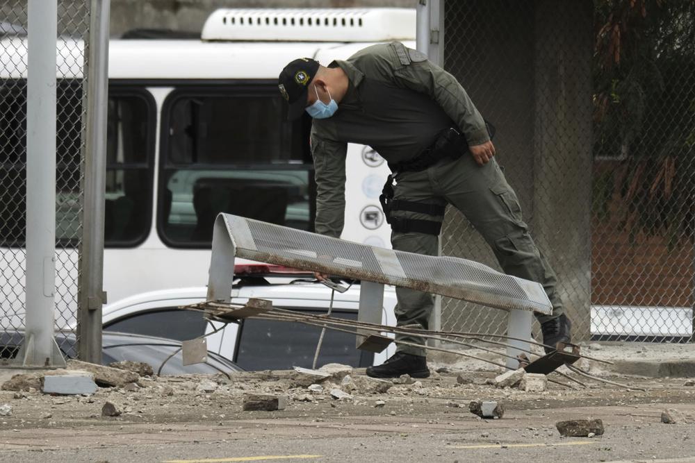 A police officer inspects damage at a police station after a bomb exploded in Cucuta, Colombia, Monday, Aug. 30, 2021, near the Venezuelan border. (AP Photo/Ferley Ospina)