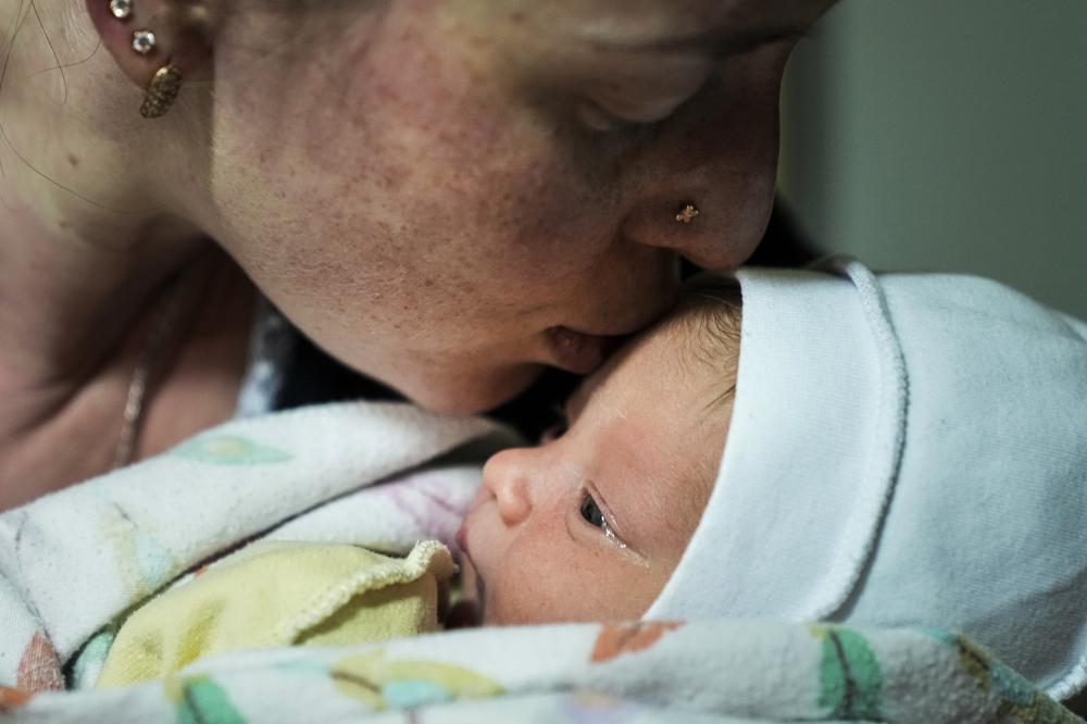 كاترينا سوهاروكوفا تقبل ابنها حديث الولادة ماكار في قبو مستشفى للولادة تم تحويله إلى جناح طبي واستخدم كمأوى من القنابل في ماريوبول ، أوكرانيا ، يوم الاثنين 28 فبراير 2022 (AP Photo / Evgeniy Maloletka)