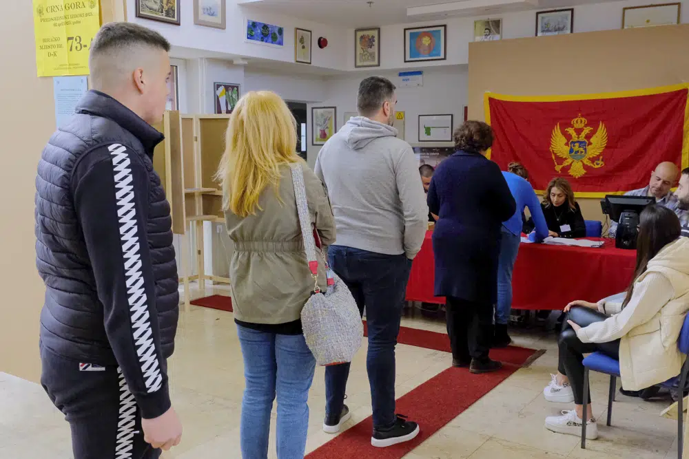 People wait in line at a polling station in Montenegro's capital Podgorica, Sunday, April 2, 2023. Montenegrins are casting ballots on Sunday in a runoff presidential election that is a battle between a long-serving pro-Western incumbent and a newcomer promising changes in the small NATO member state in Europe that has been locked in political turmoil. (AP Photo/Risto Bozovic)