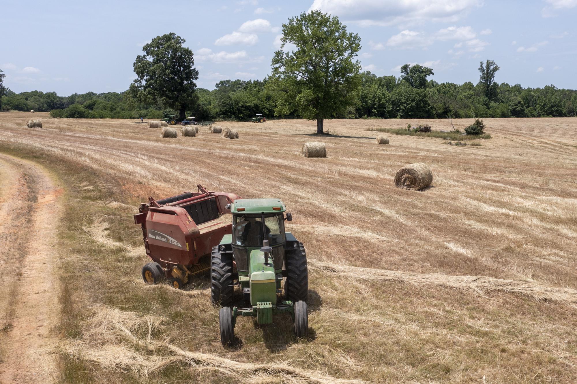 Farmer John Boyd Jr., runs his hay bailer at his farm in Boydton, Va., Thursday, May 27, 2021. Just two generations out of slavery, by 1910 Black farmers had amassed more than 16 million acres of land and made up about 14 percent of farmers. The fruit of their labors fed much of America. In 2021, they have fewer than 4.7 million acres. (AP Photo/Steve Helber)