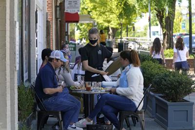 Comensales son asistidos en un café en Franklin Steet, en Chapel Hill, Carolina del Norte, el 16 de abril del 2021. Los consumidores estadounidenses absorbieron otro aumento de precios en mayo _ un incremento de 0,6% respecto a abril y de 5% en el último año, el mayor aumento de la inflación para 12 meses desde el 2008. (AP Foto/Gerry Broome)
