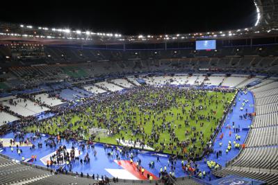 ARCHIVO - En esta foto del 13 de noviembre del 2015, espectadores invaden la cancha en el estadio Stade de France tras concluir un partido amistoso entre Francia y Alemania en Saint Denis, en las afueras de París.  Víctimas de los ataques terroristas del 2015 en París comenzaron a declarar el 28 de septiembre del 2021 sobre la noche que dejó 130 muertos y decenas de heridos y las secuelas que ha dejado en los primeros testigos de la masacre. El testimonio comenzó con los policías montados que vieron a los dos primeros atacantes suicidas en el estadio nacional de fútbol. Los gendarmes, que eran 13 e n el sitio esa noche, estaban trabajando en control de muchedumbres en las afueras del estadio para el partido Francia-Alemania y absorbieron las ondas expansivas de las explosiones.   (AP Foto/Michel Euler)