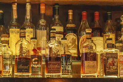 A collection of bottles of Pappy Van Winkle bourbons are seen on the top shelf right, among other fine whiskies at the "Far Bar," located in the historic Far East Building in the heart of Little Tokyo in Los Angeles on Saturday, March 4, 2023. Buttery, smooth, oaky. These are characteristics of the best bourbons, and a growing cult of aficionados is willing to pay an astonishing amount of money for these increasingly scarce premium spirits — and even bend or break laws. (AP Photo/Damian Dovarganes)