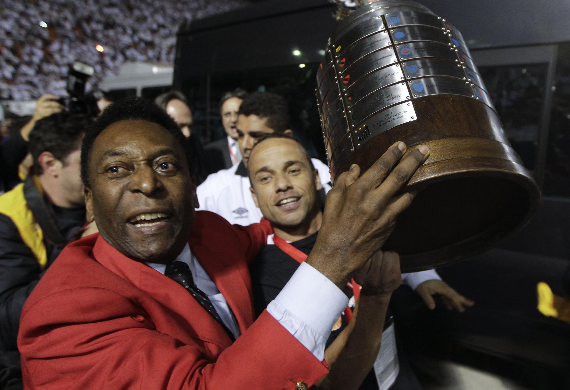 FILE - Former Brazilian soccer player Pele, left, celebrates at the end of the Copa Libertadores soccer final match between Brazil's Santos and Uruguay's Penarol in Sao Paulo, Brazil, June 22, 2011. Santos won 2-1. Pelé, the Brazilian king of soccer who won a record three World Cups and became one of the most commanding sports figures of the last century, died in Sao Paulo on Thursday, Dec. 29, 2022. He was 82. (AP Photo/Andre Penner, File)